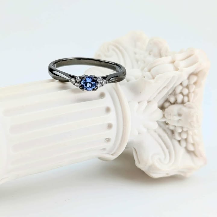 Czarny pierścionek z tanzanitem i diamentami po bokach